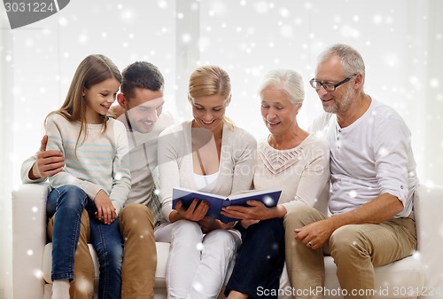 Image of happy family with book or photo album at home