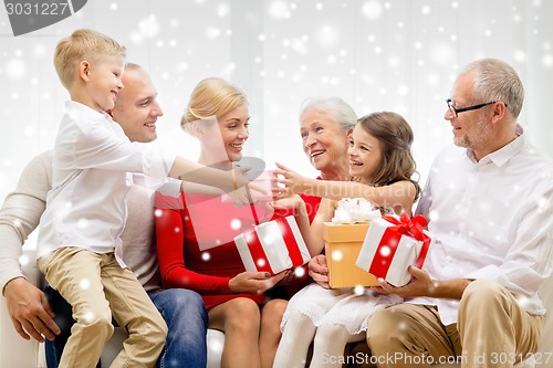 Image of smiling family with gifts at home