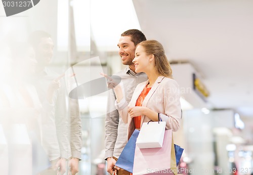 Image of happy young couple with shopping bags in mall