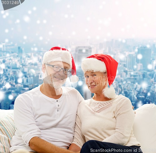 Image of happy senior couple in santa helper hats