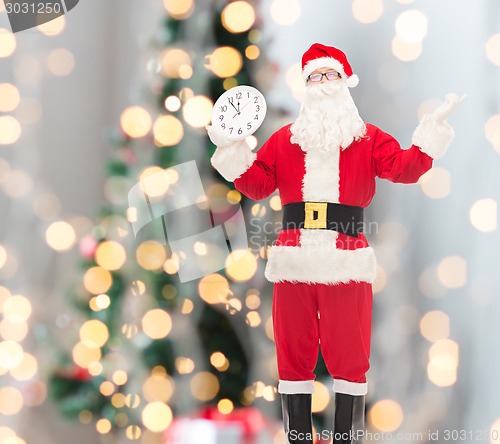 Image of man in costume of santa claus with clock