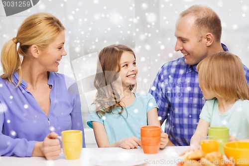 Image of happy family with two kids having breakfast