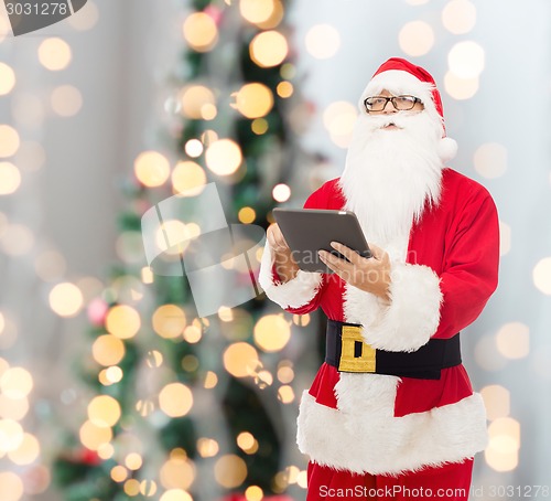 Image of man in costume of santa claus with tablet pc