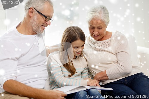 Image of smiling family with book at home