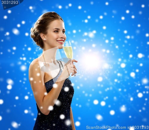 Image of smiling woman holding glass of sparkling wine