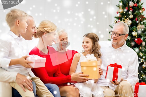 Image of smiling family with gifts at home