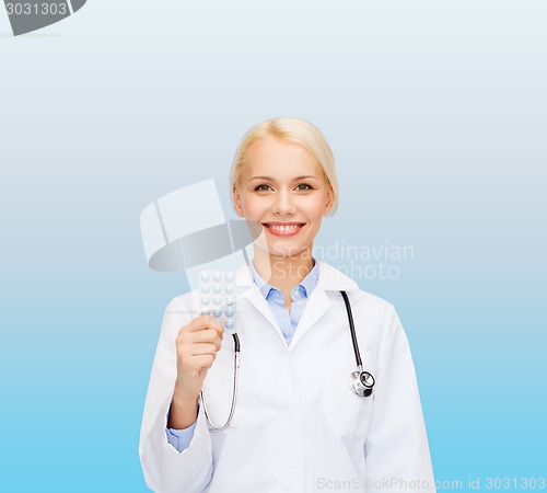 Image of smiling female doctor with pills