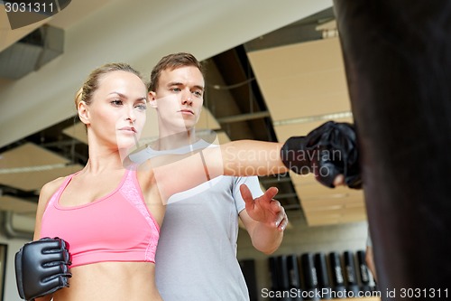 Image of woman with personal trainer boxing in gym