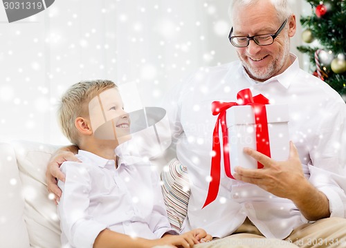 Image of smiling grandfather and grandson at home