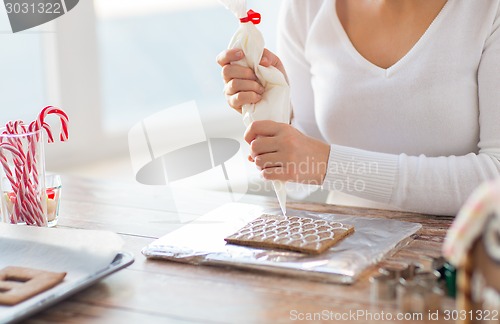 Image of close up of woman making gingerbread houses