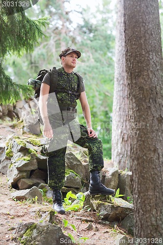 Image of young soldier with backpack in forest