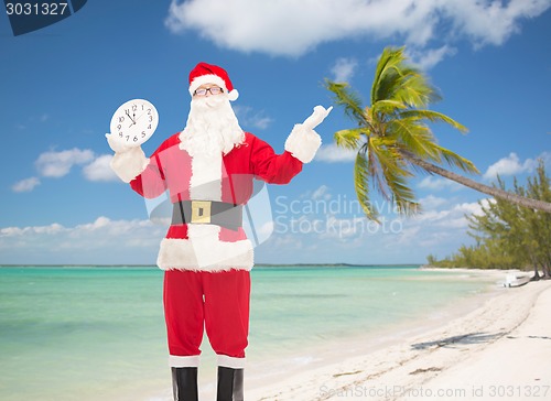 Image of man in costume of santa claus with clock