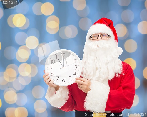 Image of man in costume of santa claus with clock