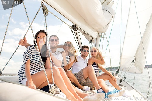 Image of smiling friends sitting on yacht deck