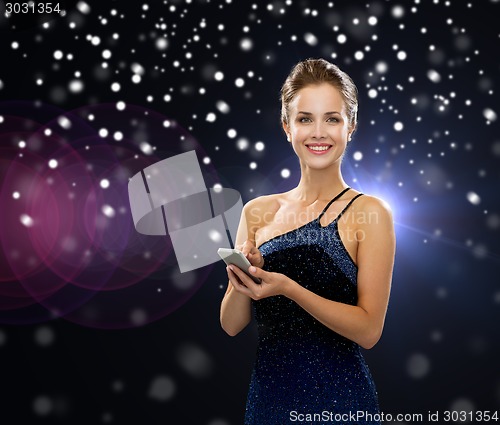 Image of smiling woman in evening dress with smartphone