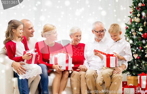 Image of smiling family with gifts at home