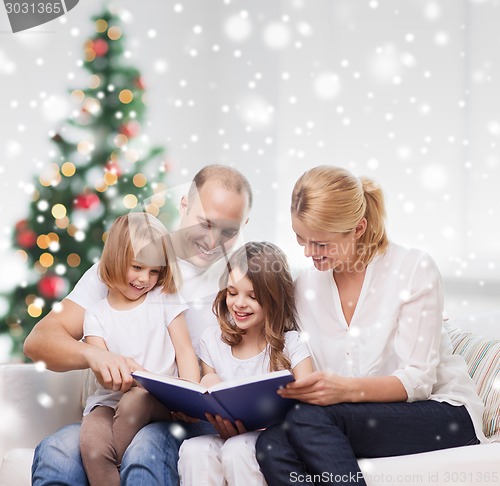 Image of happy family with book at home