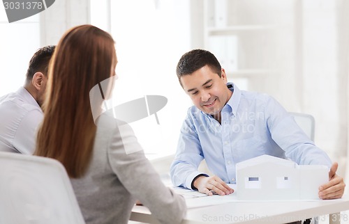 Image of couple looking at model of their house at office