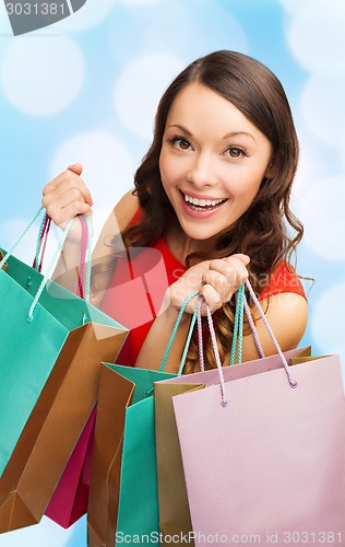 Image of smiling woman with colorful shopping bags