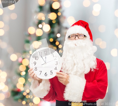 Image of man in costume of santa claus with clock