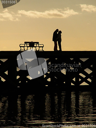 Image of Kissing Couple Silhouette On A Pier