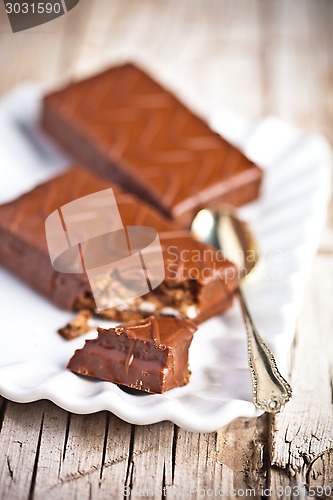 Image of dark chocolate cakes and spoon on a plate 