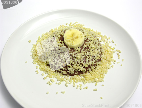 Image of Chocolate pudding with banana slice and almond slivers