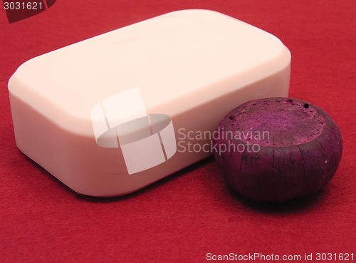 Image of Pink soap with decoration articles on a  red background