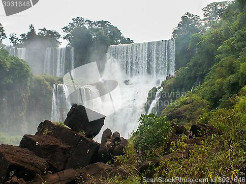 Image of Iguazu Falls Framed By Rocks And Foliage