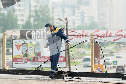 Image of Worker holds a gas torch to waterproofing