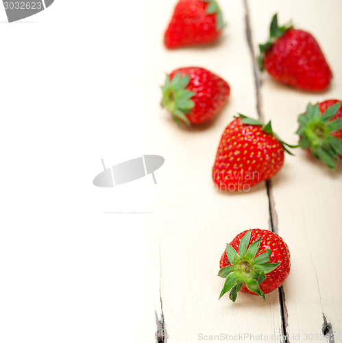 Image of fresh organic strawberry over white wood