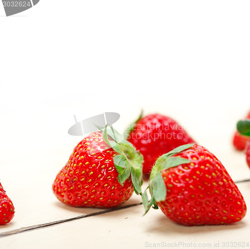 Image of fresh organic strawberry over white wood