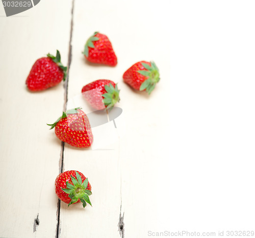 Image of fresh organic strawberry over white wood