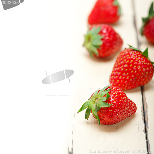 Image of fresh organic strawberry over white wood