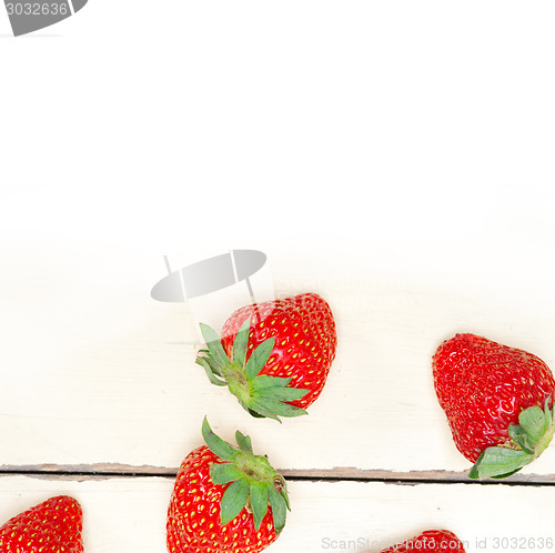 Image of fresh organic strawberry over white wood