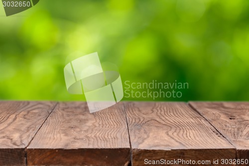 Image of Empty wooden table against green background