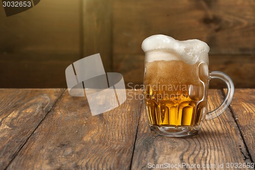 Image of Light beer in mug on wood