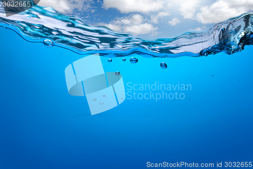 Image of Splash of blue water with bubbles and blue sky