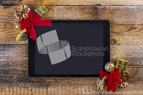 Image of tablet pc with  christmas decorations on wooden background
