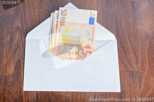 Image of Open envelope with euro banknotes on table