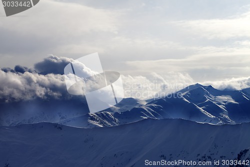 Image of Snowy mountains in haze at sunny evening