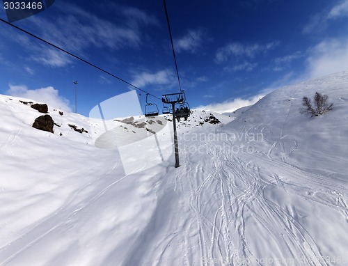 Image of Chair-lift and off-piste slope in sun day