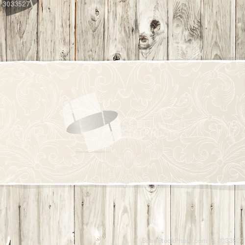 Image of Torn paper on wooden texture