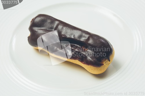 Image of Single chocolate eclair on white  plate