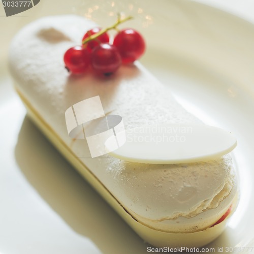 Image of Single eclair with space for text on white plate.