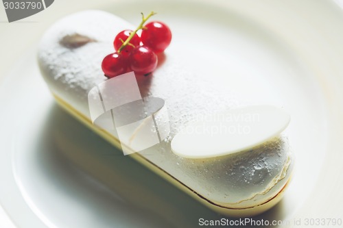 Image of Single eclair with space for text on white plate.