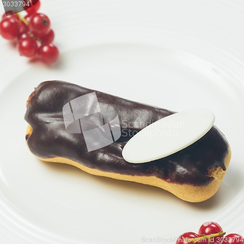 Image of Single chocolate eclair on white  plate