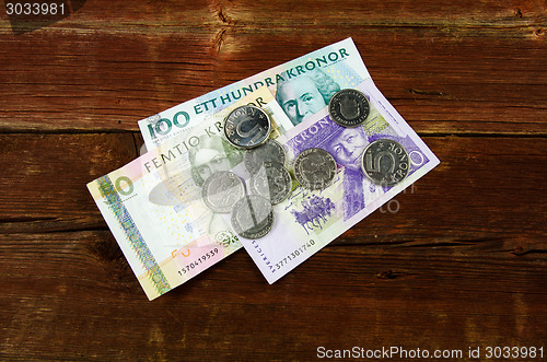 Image of Swedish cash at an old red wooden plank