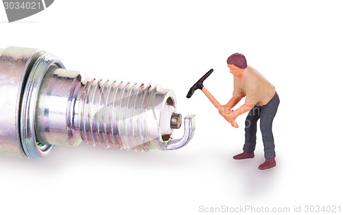 Image of Miniature worker working on a sparkplug