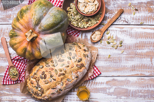 Image of White bread with pumpkin seeds on wooden table in rustic style